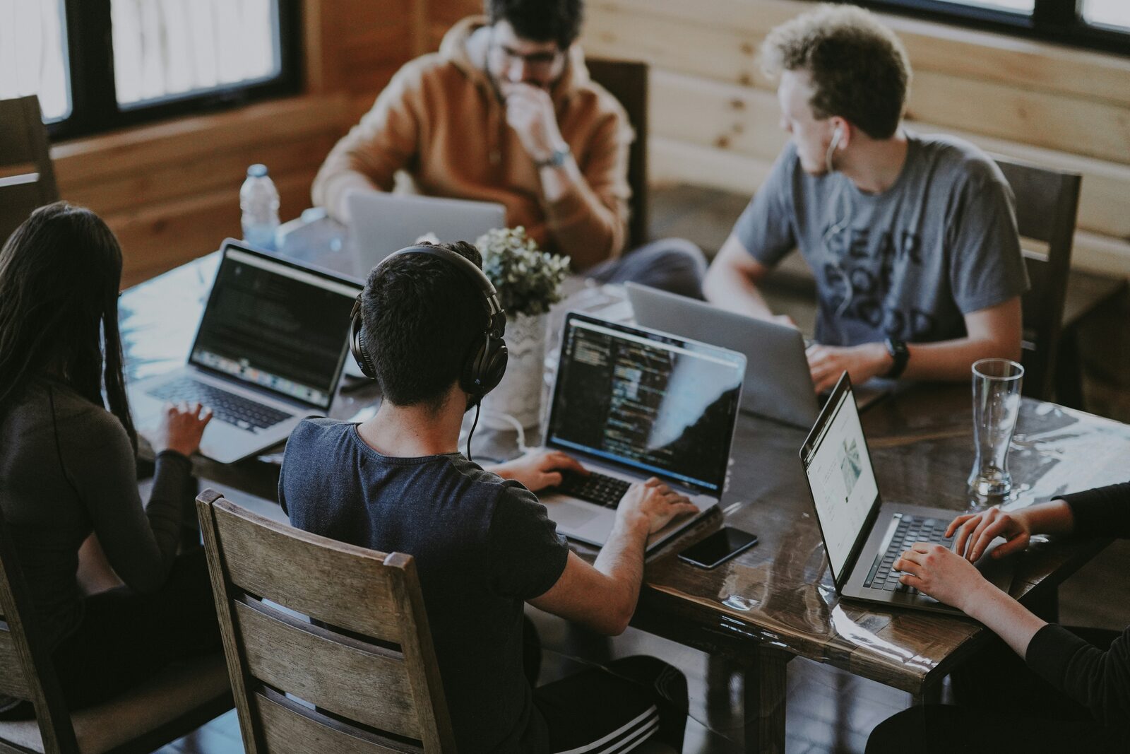 A startup team working together on laptops around a shared table.